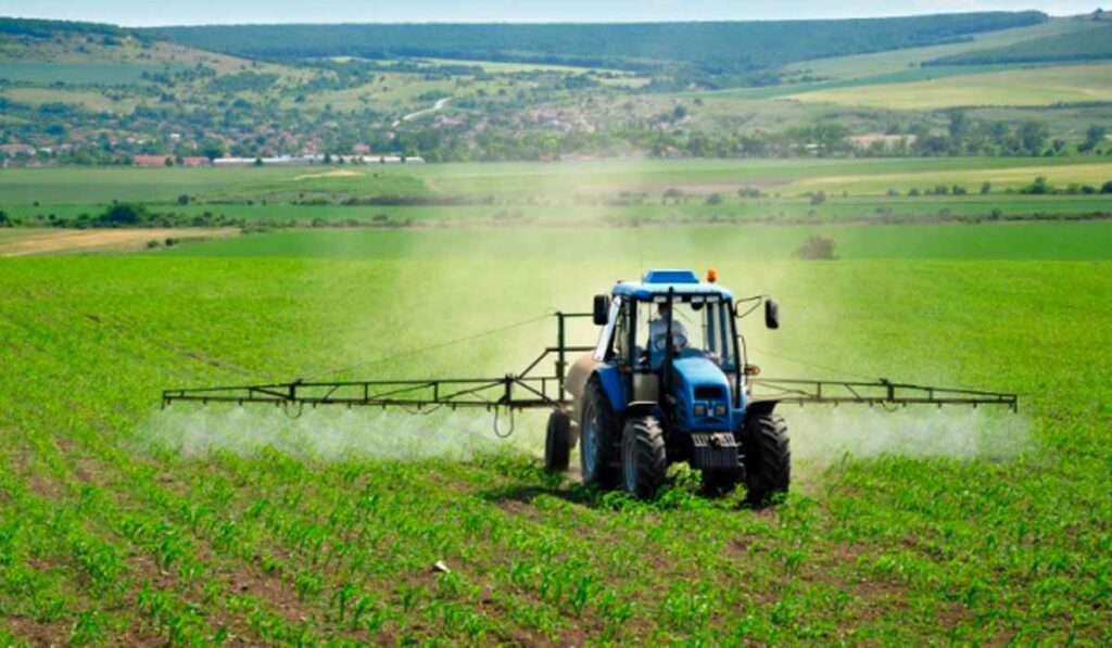 Trator em operação de pulverização de adubo foliar