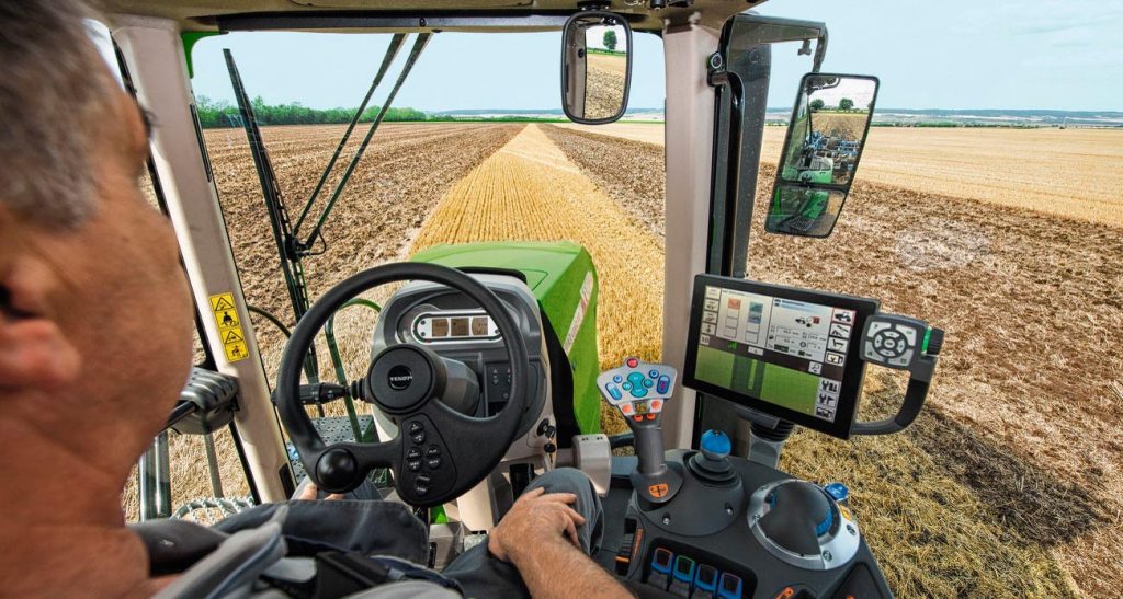 Agricultor conduzindo máquina com alta tecnologia embracada