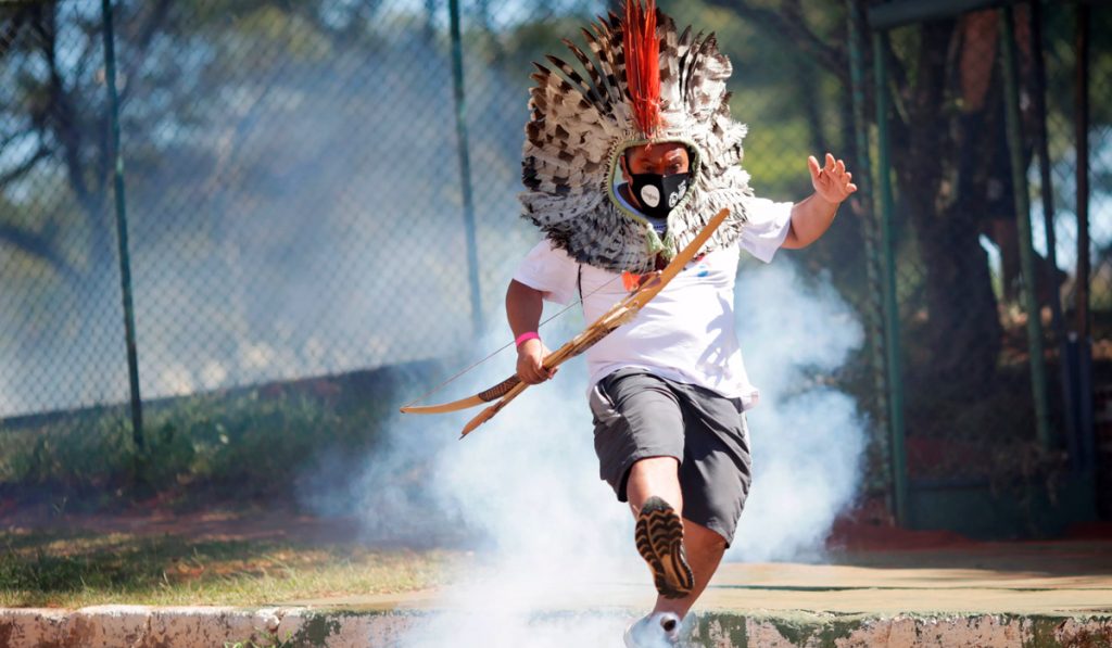 Líder indígena Kretan Kaingang chuta de volta bomba de gás lacrimogêneo lançada pela polícia contra indígenas durante protesto em frente ao Congresso (Foto: REUTERS/Ueslei Marcelino)