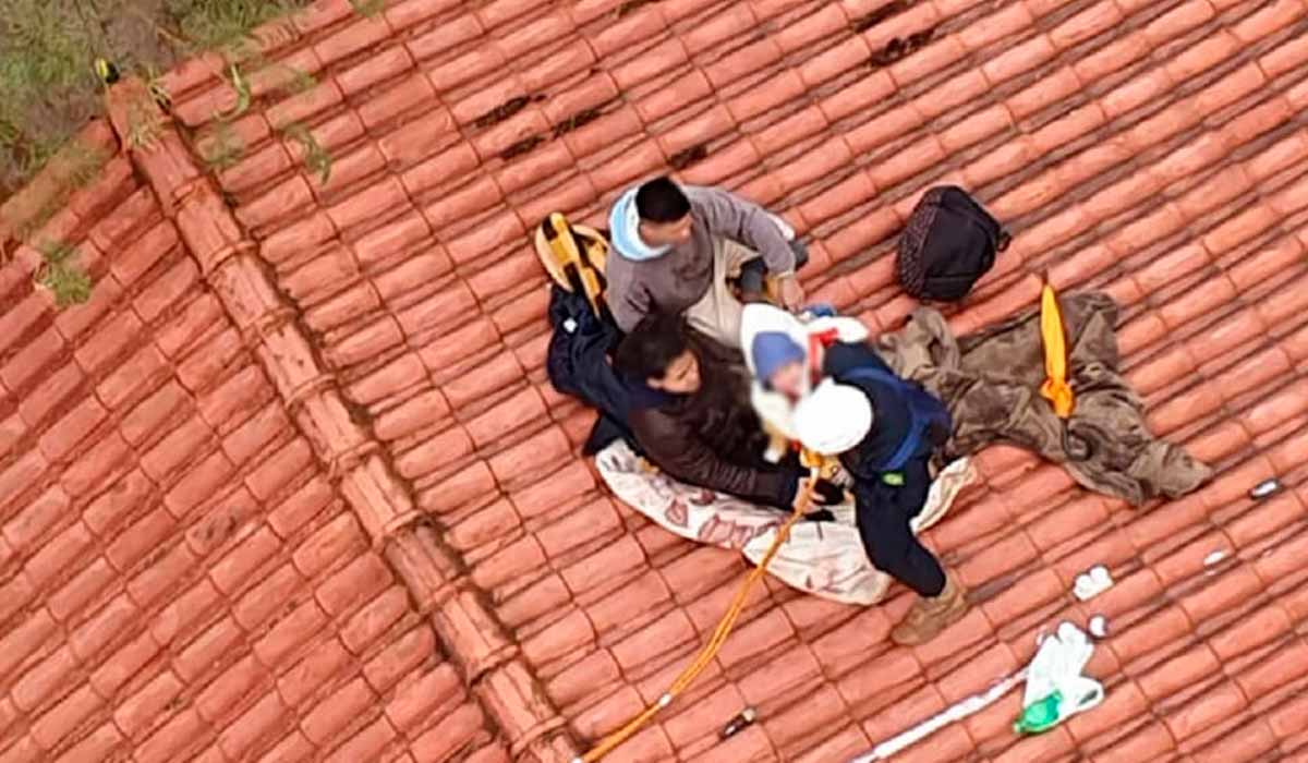 Família isolada sobre o telhado de uma residência na área rural, aguardando o resgate por helicóptero