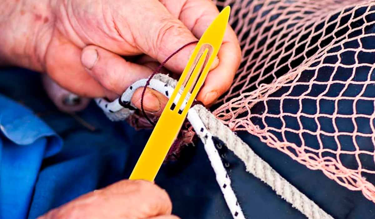 Pescador consertando rede de pesca