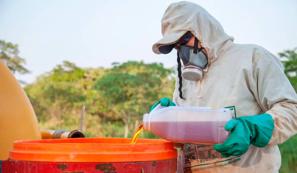 Abastecendo com agrotóxico o pulverizador acoplado ao trator